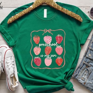 a green t - shirt with strawberries on it