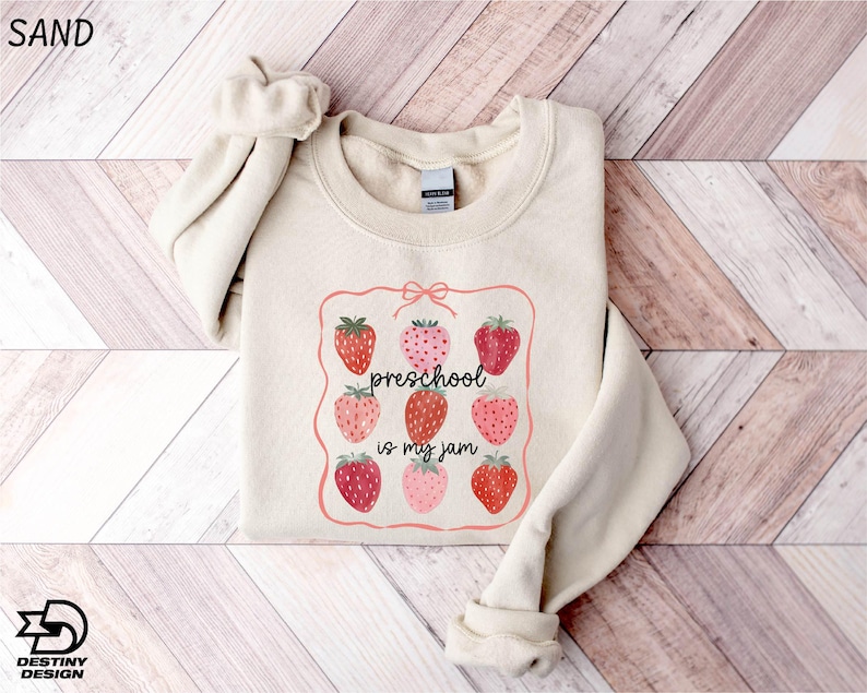 a sweater with strawberries on it on a wooden floor