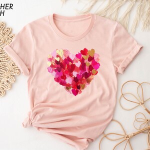 a pink t - shirt with a heart of hearts on it
