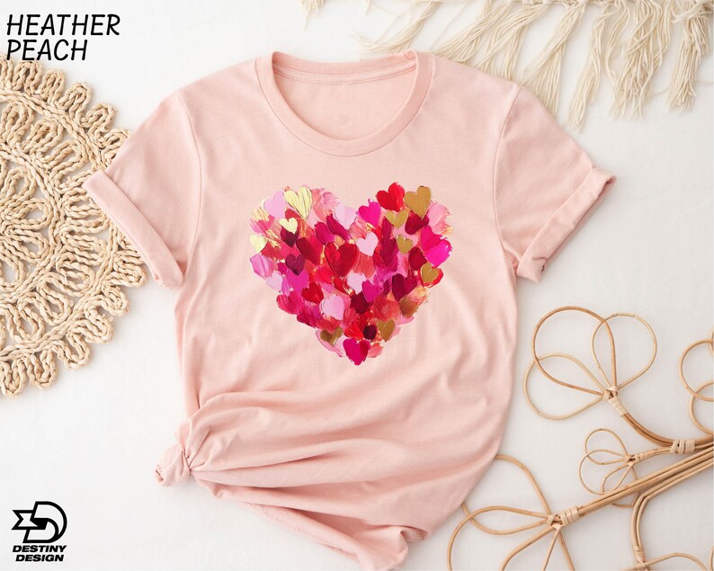 a pink t - shirt with a heart of hearts on it