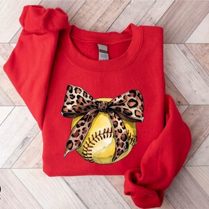 a red shirt with a baseball and a bow on it