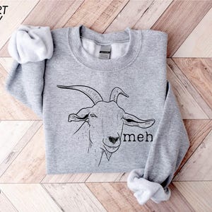 a grey sweatshirt with a goat on it
