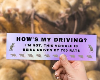 May include: A humorous bumper sticker with a purple background and white text that reads "HOW'S MY DRIVING? I'M NOT. THIS VEHICLE IS BEING DRIVEN BY 700 RATS". The sticker features a row of cartoon rats running across the bottom.
