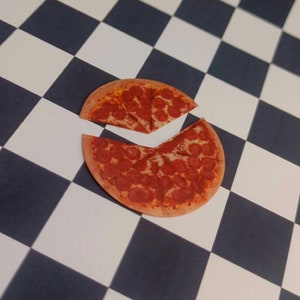 May include: A pepperoni pizza cut into slices on a black and white checkered surface.