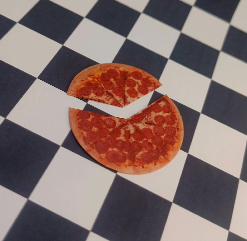 May include: A pepperoni pizza cut into slices on a black and white checkered surface.