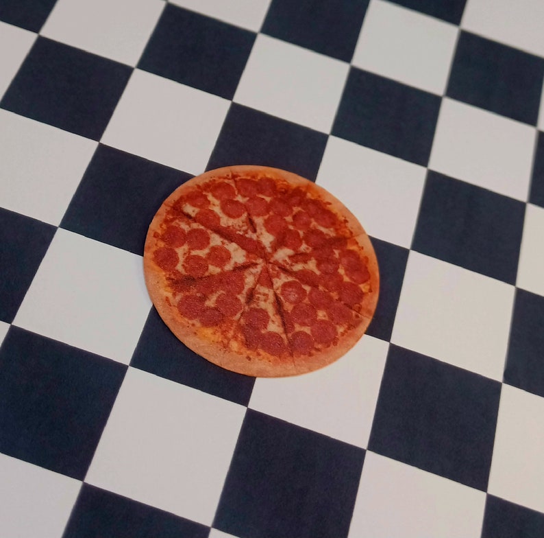 May include: A pepperoni pizza with a red sauce base and a golden brown crust. The pizza is sliced into eight pieces and is sitting on a black and white checkered surface.