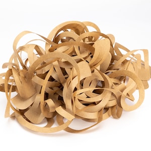 Puede incluir: Un montón de tiras de papel marrón, retorcidas y enroscadas en una forma orgánica desordenada. El papel es marrón claro y tiene una superficie ligeramente texturizada.