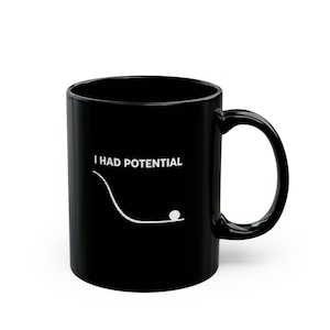 May include: Black ceramic mug with the white text "I HAD POTENTIAL". A white line graphic shows a ball rolling down a curved path. The mug has a large handle for easy gripping.