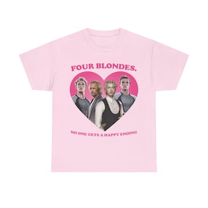 May include: A light pink short-sleeve t-shirt featuring a large dark pink heart graphic containing four blonde individuals. Above the heart is the text "FOUR BLONDES." and below the heart is the text "NO ONE GETS A HAPPY ENDING" in dark pink.