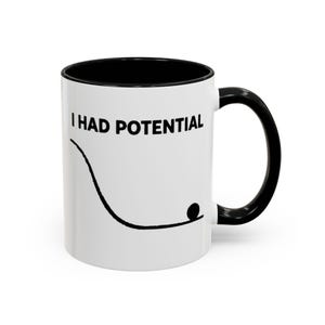 May include: A white ceramic mug with a black handle and the text "But First, Coffee" in a handwritten style. The mug is on a white surface. The mug is 10 cm tall.