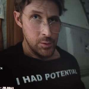 Könnte beinhalten: Schwarzes T-Shirt mit dem weißen Text "I HAD POTENTIAL". Die Person auf dem Bild trägt eine Brille und hat einen Bart.
