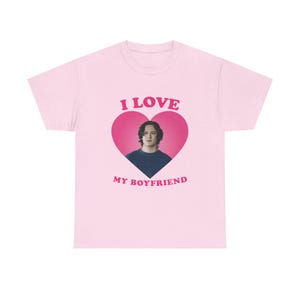 Puede incluir: Camiseta rosa con un gráfico en forma de corazón que presenta la cara de un hombre y el texto "I LOVE MY BOYFRIEND".