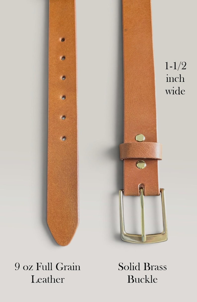 May include: A tan leather belt featuring a solid brass buckle and a series of adjustment holes. The belt is 1-1/2 inch wide and made of 9 oz full grain leather. The text 1-1/2 inch wide, 9 oz Full Grain Leather, and Solid Brass Buckle is visible.