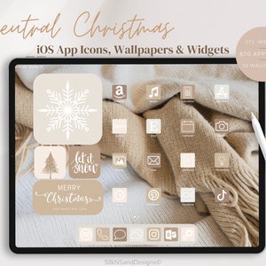 May include: A digital tablet displaying a neutral Christmas themed iOS app icon set. The icons are white on a beige background. The icons include a snowflake, a Christmas tree, a text box that says "let it snow", and a text box that says "Merry Christmas and Happy New Year".