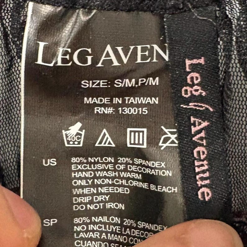 May include: A black clothing tag with the brand name "LEG AVEN" in white block letters. The tag includes washing instructions, size information, and the text "MADE IN TAIWAN". The tag also lists the materials used.
