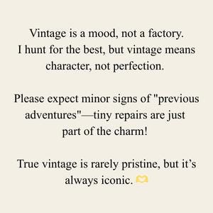 May include: Cream-colored background with black text. The text reads: "Vintage is a mood, not a factory. I hunt for the best, but vintage means character, not perfection. Please expect minor signs of 'previous adventures' - tiny repairs are just part of the charm! True vintage is rarely pristine, but it's always iconic."