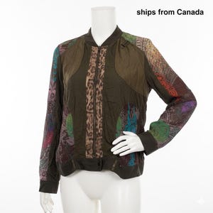 Puede incluir: Una chaqueta tipo bomber de manga larga con un panel central de estampado de leopardo, paneles laterales en verde oliva y mangas con patrones florales y de cachemira multicolores. Incluye cierre de cremallera y puños acanalados.