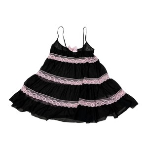 May include: Black babydoll dress with spaghetti straps and a tiered skirt. The dress features pink lace trim and a small pink bow at the bust. The lightweight fabric creates a flowing silhouette.