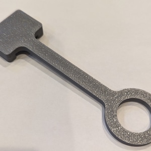 Peut inclure: Une clé en plastique grise avec une tête carrée et un trou rond à l'extrémité.