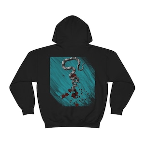 Könnte beinhalten: Schwarzer Kapuzenpullover mit einem grafischen Aufdruck einer Schlange mit Blutspritzer auf einem türkisfarbenen Hintergrund.