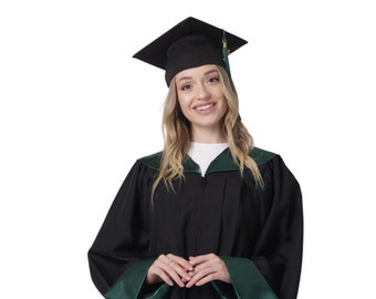 Puede incluir: Una persona vistiendo una toga de graduación negra con ribetes verdes y un birrete de graduación negro. La toga tiene una cremallera y el birrete tiene una borla dorada.
