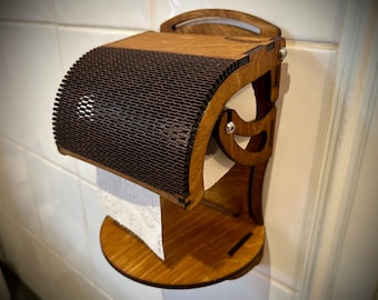 May include: A wooden toilet paper holder with a brown, slatted design. The holder is mounted on a white tiled wall and has a roll of toilet paper hanging from it.