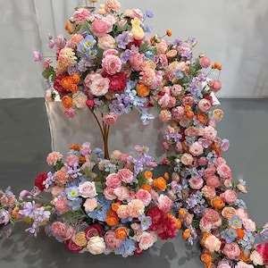 Oranje en felroze zijdebloemstuk: decoratie gangpad bruiloft