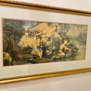 May include: A framed print of a painting depicting an angel with wings, reaching down to two children on a bridge over a stream. The angel is wearing a white gown and has long blonde hair. The children are wearing colourful clothing and are looking up at the angel. The background is a lush green forest.