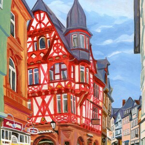 Pu&ograve; includere: Dipinto a olio di una scena di strada europea. L'edificio principale &egrave; una casa a graticcio rossa e bianca con una torre grigio scuro. Il cielo blu e gli altri edifici creano una vista dettagliata della citt&agrave;.
