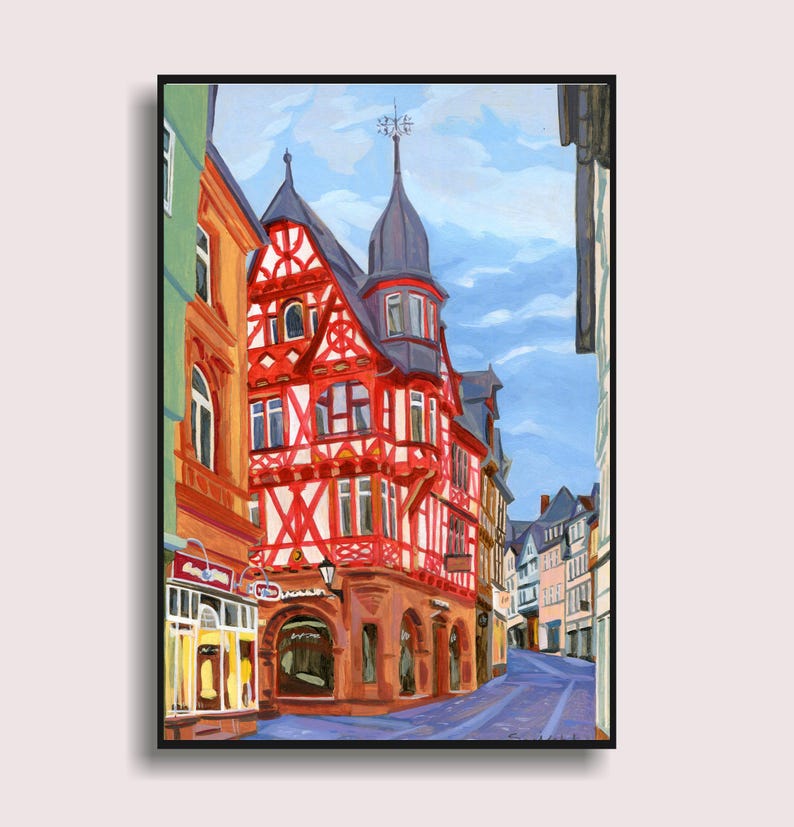 Pu&ograve; includere: Dipinto a olio di una scena di strada europea. Il punto focale &egrave; un edificio a graticcio rosso e bianco con un campanile scuro. Altri edifici costeggiano la strada, dipinti in vari colori. Un cielo blu con nuvole riempie lo sfondo.