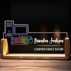 May include: A wooden desk nameplate with a glowing neon computer graphic. The nameplate reads "Brandon Johnson, Computer Science Teacher" in white script. The computer graphic includes a monitor, keyboard, mouse, and tower.