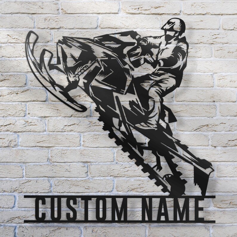 Puede incluir: Silueta negra de metal de una persona conduciendo una moto de nieve, con las palabras "CUSTOM NAME" debajo.