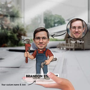Peut inclure: Figurine de plombier personnalisée avec une illustration de style cartoon. La figurine tient une clé à molette et un tuyau. La figurine porte un nom et un texte personnalisés à la base. Une photo est incluse.
