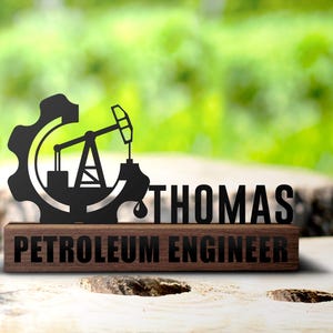 Może przedstawiać: Drewniana tabliczka z czarnym metalowym projektem platformy wiertniczej i koła zębatego. Tabliczka zawiera napis "Thomas Petroleum Engineer".