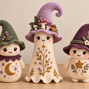 May include: Three crocheted dolls with cream-colored bodies and pointed hats. The left doll has a green hat with a moon charm. The center doll is taller with a lavender hat adorned with mushrooms. The right doll has a purple hat with a star charm.