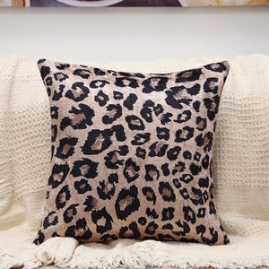May include: A brown and black leopard print throw pillow with a soft, velvety texture.