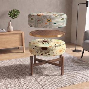 May include: A multi-tiered circular ottoman featuring a wooden base with crossed legs, a middle wooden tray with a gold rim, and two upholstered cushions with distinct retro-inspired patterns in shades of orange, teal, brown, and cream.