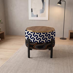 May include: A round ottoman with a wooden top and a gold metal rim. The upper section features a blue and white geometric pattern, while the lower section displays a black, orange, and grey wavy line design, supported by four black legs.