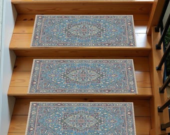 May include: Three blue and beige patterned non-slip stair treads with a traditional Persian design. The treads are placed on wooden stairs.