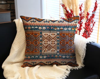 Vierkant kelimkussen met complex geometrisch patroon in roest-, groenblauw-, beige- en roze tinten, gezellig decoratief kussen voor bank- of boho-interieurs