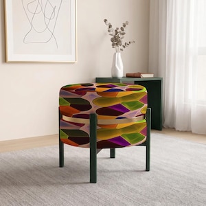 May include: A round ottoman featuring a vibrant, multi-colored geometric pattern of overlapping shapes in shades of yellow, orange, purple, and green. The seat is supported by a dark green wooden frame with four legs and a central horizontal band.