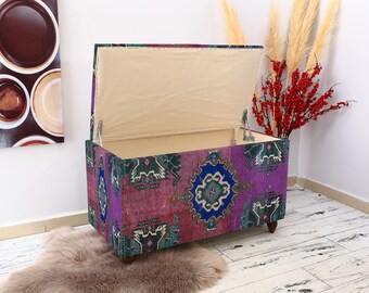 May include: A colorful storage ottoman with a patterned fabric cover. The ottoman has a hinged lid that opens to reveal a storage compartment.
