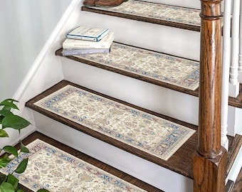 May include: Beige and blue patterned stair treads with a floral design. The treads are placed on a wooden staircase with a brown handrail.