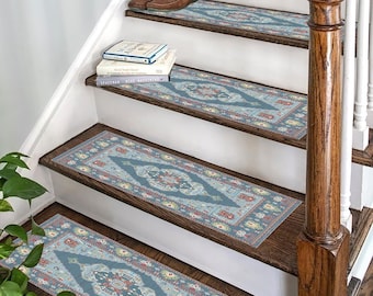 May include: A set of four blue and red patterned stair treads with a traditional design. The treads are placed on a wooden staircase with a white railing.