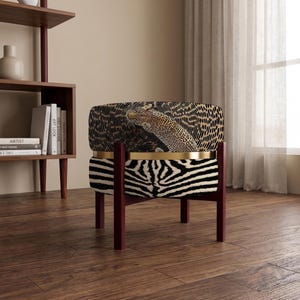 Peut inclure: Un fauteuil bas doté d'un dossier incurvé à motif léopard et d'une assise recouverte d'un tissu à rayures zébrées noires et blanches. La chaise est soutenue par une structure en bois foncé et rehaussée d'une bande métallique dorée horizontale.