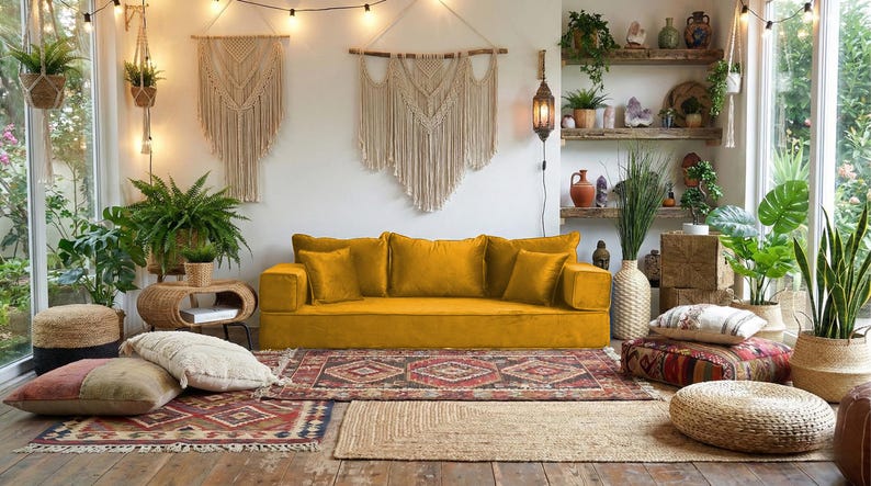 May include: A cozy living room with a mustard yellow sofa, patterned rugs, and macrame wall hangings. The room is filled with plants, including ferns and snake plants, and has a bohemian aesthetic. Decorative pillows and poufs add to the inviting atmosphere.