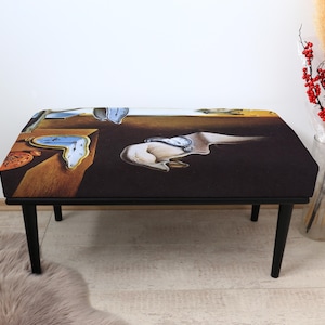 May include: A black bench with a surrealist painting of melting clocks and a brown background. The bench has a rectangular top and black legs. The artwork is reminiscent of Salvador Dalí's famous painting, "The Persistence of Memory."
