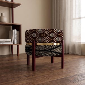 May include: A round ottoman featuring a dark brown and white ikat patterned top and a black and white striped base, separated by a gold-toned metal band. The piece is supported by four dark wood legs arranged in a cross-frame structure.
