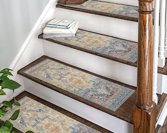 May include: A set of four stair treads with a blue, orange, and beige patterned design. The treads are placed on a wooden staircase with a white railing.