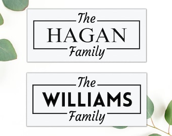 May include: Two white signs with black text. The top sign says "The HAGAN Family" and the bottom sign says "The WILLIAMS Family".